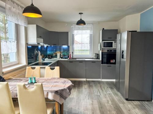 a kitchen with a wooden table and a kitchen with a table and chairs at Holiday Home Hostyn Hills by Interhome in Bystřice pod Hostýnem