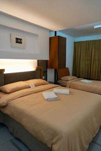 a hotel room with two beds with towels on them at PCB The Seven Gardens Resort & Spa in Kota Bharu