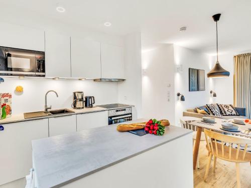 a kitchen with white cabinets and a table at Apartment Fiddy by Interhome in Lembruch