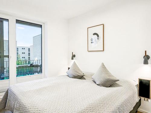 a white bedroom with a bed and a large window at Apartment Fiddy by Interhome in Lembruch