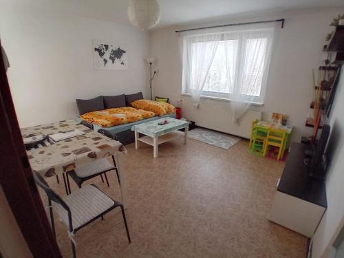 a living room with a bed and a table at Apartmán Na Horách in Zlatá Olešnice