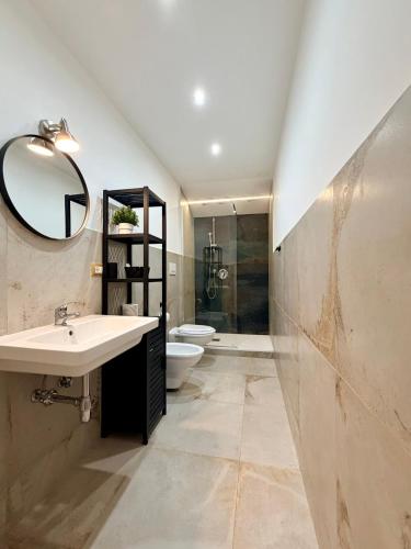 a bathroom with a sink and a toilet and a mirror at Nautilus B&B in Scalea