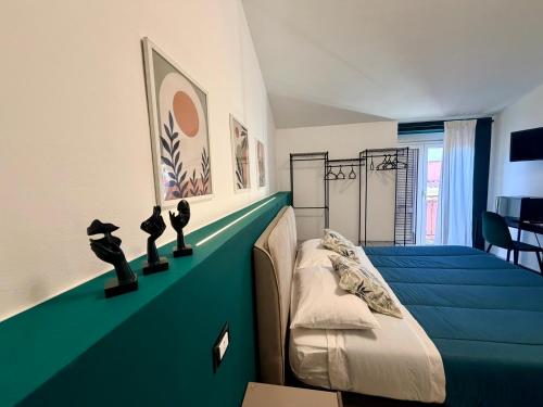 Un dormitorio con una cama y una pared azul. en Nautilus B&B, en Scalea