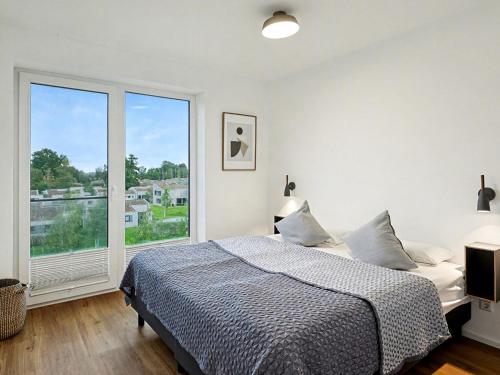 a bedroom with a bed and a large window at Apartment Seezauber by Interhome in Lembruch