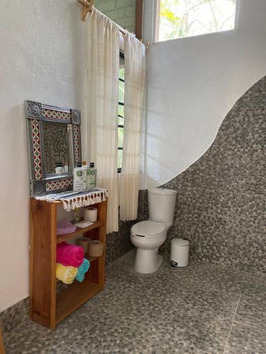 a bathroom with a toilet and a mirror at Casa Kata in Zipolite