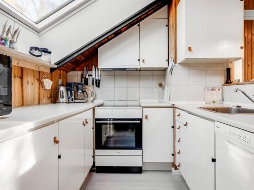 a kitchen with white cabinets and a skylight at Holiday Home Else - 470m from the sea by Interhome in Østerby Havn