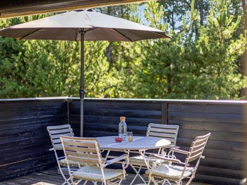 a table and chairs with an umbrella on a deck at Holiday Home Reinhardt - 800m from the sea by Interhome in Mølby