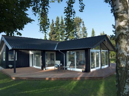 a modular home with a deck and a house at Holiday Home Antonina - 775m from the sea by Interhome in Gudmindrup