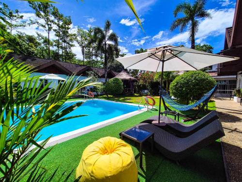 a pool with a chair and an umbrella and a table and a swing at SunzEn Palawan, Resort in Coron