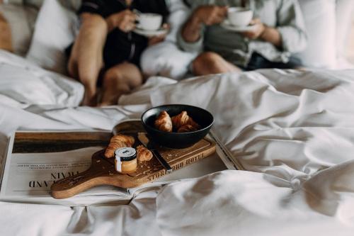 Una bandeja de comida con un tazón de nueces sobre una cama en Storfjord Hotel, en Skodje