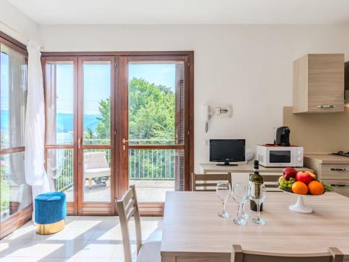 a kitchen and living room with a table with wine glasses at Apartment Borgo Castello-9 by Interhome in Argegno