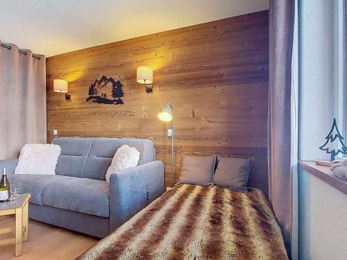 a living room with a blue couch and a wooden wall at Studio Les Olympiades-16 by Interhome in Val Thorens