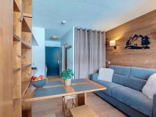 a living room with a blue couch and a table at Studio Les Olympiades-16 by Interhome in Val Thorens