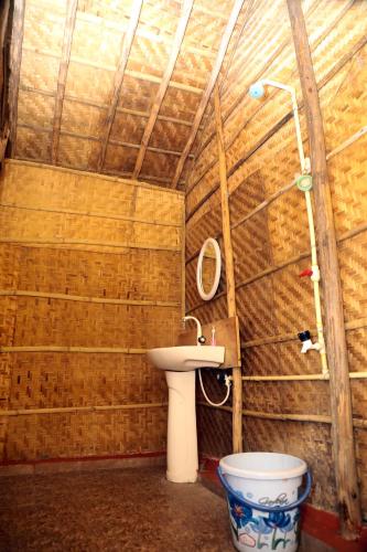 a bathroom with a toilet and a sink at Shanthi Dhama Resort, Hampi in New Hampi