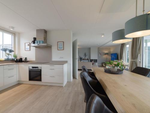 eine Küche und ein Esszimmer mit einem Holztisch und Stühlen in der Unterkunft Holiday Home Ganuenta by Interhome in Colijnsplaat