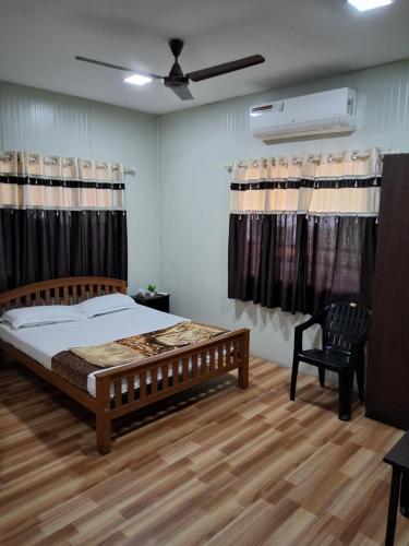 a bedroom with a bed and a ceiling fan at Vidara Budget Stay in Trivandrum
