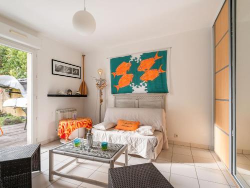 ein Wohnzimmer mit einem Bett und einem Tisch in der Unterkunft Holiday Home Monoi by Interhome in Lancieux