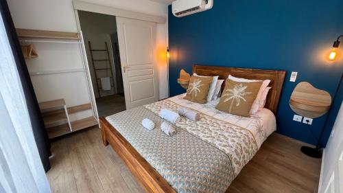 ein kleines Schlafzimmer mit einem Bett mit blauen Wänden in der Unterkunft Longanea 1 in Saint-Pierre