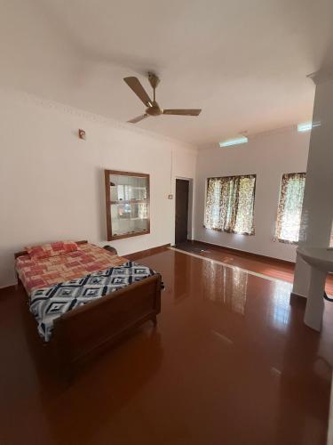 Mūvattupulaheritage mansion的一间卧室，里面有一张床和一个吊扇