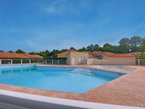 a large swimming pool in the middle of a yard at Holiday Home Les Villas de La Palmyre by Interhome in Les Mathes