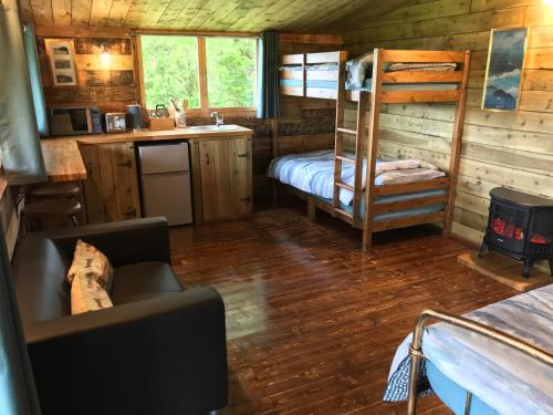 a cabin with a bunk bed and a kitchen in it at Wild Meadow Camping in Llandysul