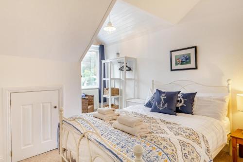 een slaapkamer met een wit bed met blauwe kussens bij 3 Bed in Lynton oc-e33950 in Lynton