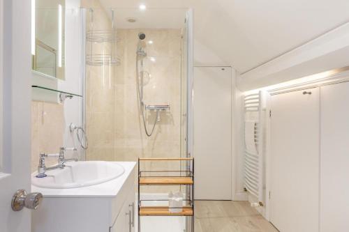 een witte badkamer met een wastafel en een douche bij 3 Bed in Lynton oc-e33950 in Lynton