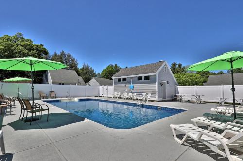 a pool with chairs and tables and umbrellas at Modern Studio for 4 Near Killington with Fireplace, Summer Pool & EV Charger in The Woods