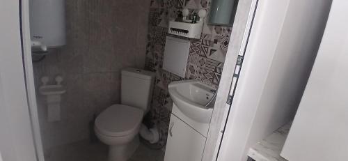a small bathroom with a toilet and a sink at Студио за двама в центъра на град Бургас in Burgas City