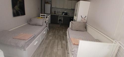 two beds in a room with a kitchen at Студио за двама в центъра на град Бургас in Burgas City