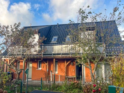 an orange house with a balcony on top of it at Kröslin Apartments in Kröslin