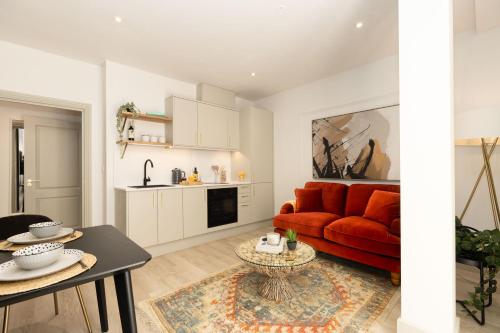 a living room with a red couch and a table at Apartment Three Pelican House in Bournemouth