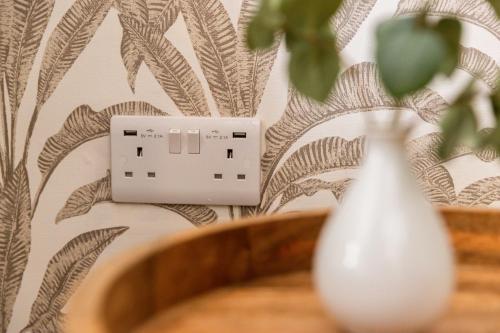 a white vase sitting next to a light switch at Apartment Three Pelican House in Bournemouth