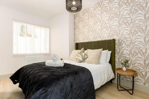 a bedroom with a bed with a patterned wall at Apartment Three Pelican House in Bournemouth