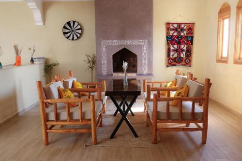 a living room with a table and chairs and a fireplace at Dar Iziki Separate Apartments in Sidi Kaouki