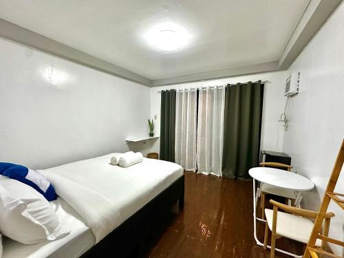 a bedroom with a bed and a table and a chair at Casa Mia in El Nido