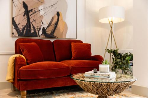 a living room with a red couch and a table at Apartment Three Pelican House in Bournemouth