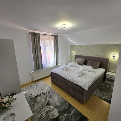 a bedroom with a large bed in a room at Casa cu Flori Moisei in Moisei