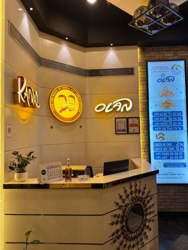 a reception desk in a restaurant with signs on the wall at 18 Rooms By OLAN in Trichūr