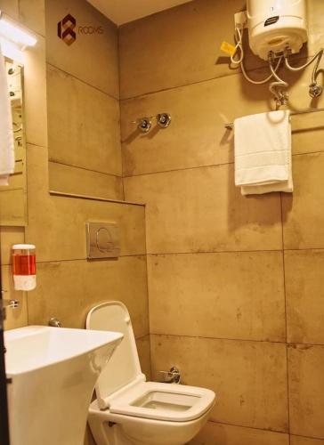 a bathroom with a white toilet and a sink at 18 Rooms By OLAN in Trichūr