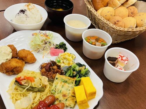 a table with a plate of food and bowls of food at Toyoko Inn Hiroshima Ekimae Ohashi Minami in Hiroshima