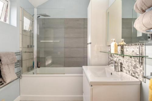 een witte badkamer met douche en wastafel bij 1 Bed in Dickleburgh oc-m33974 in Dickleburgh