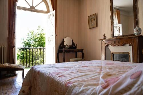 a bedroom with a bed and a large window at Villa Mon But - Maison de maître du 19ème siècle in Hagetmau