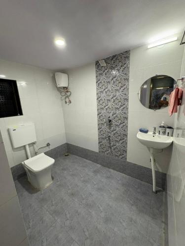 a bathroom with a toilet and a sink at Juee's Holiday Homes in Alibaug