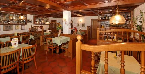 ein Restaurant mit einem Tisch und Stühlen in einem Zimmer in der Unterkunft Pension Bergstub`n in Saldenburg