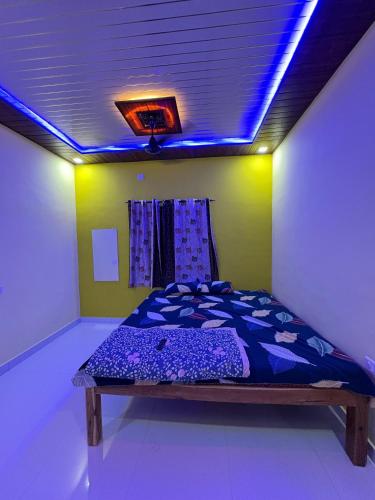 a bed in a room with a blue light at Juee's Holiday Homes in Alibaug