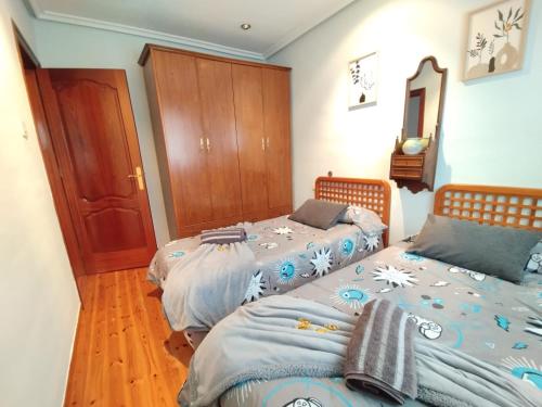 una camera da letto con due letti e pavimento in legno di Casa natural redes 