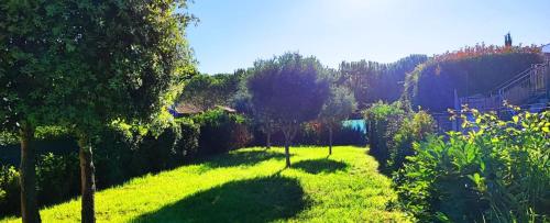 einen Garten mit grünem Gras, Bäumen und Sträuchern in der Unterkunft Villa Jardins de la Mer in Poggio-Mezzana