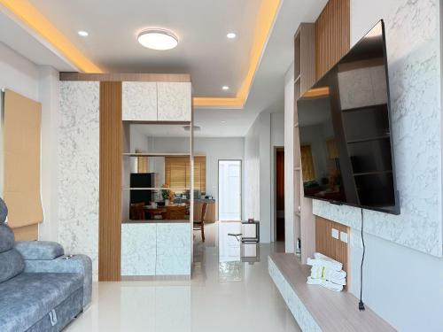 a living room with a couch and a tv at Monkey Pool Villa Krabi Ao Nang in Ao Nang Beach