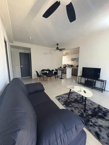 Barra ViejaEscapate a Acapulco Diamante,Depa familiar equipado的客厅里有一张蓝色的沙发和一张桌子